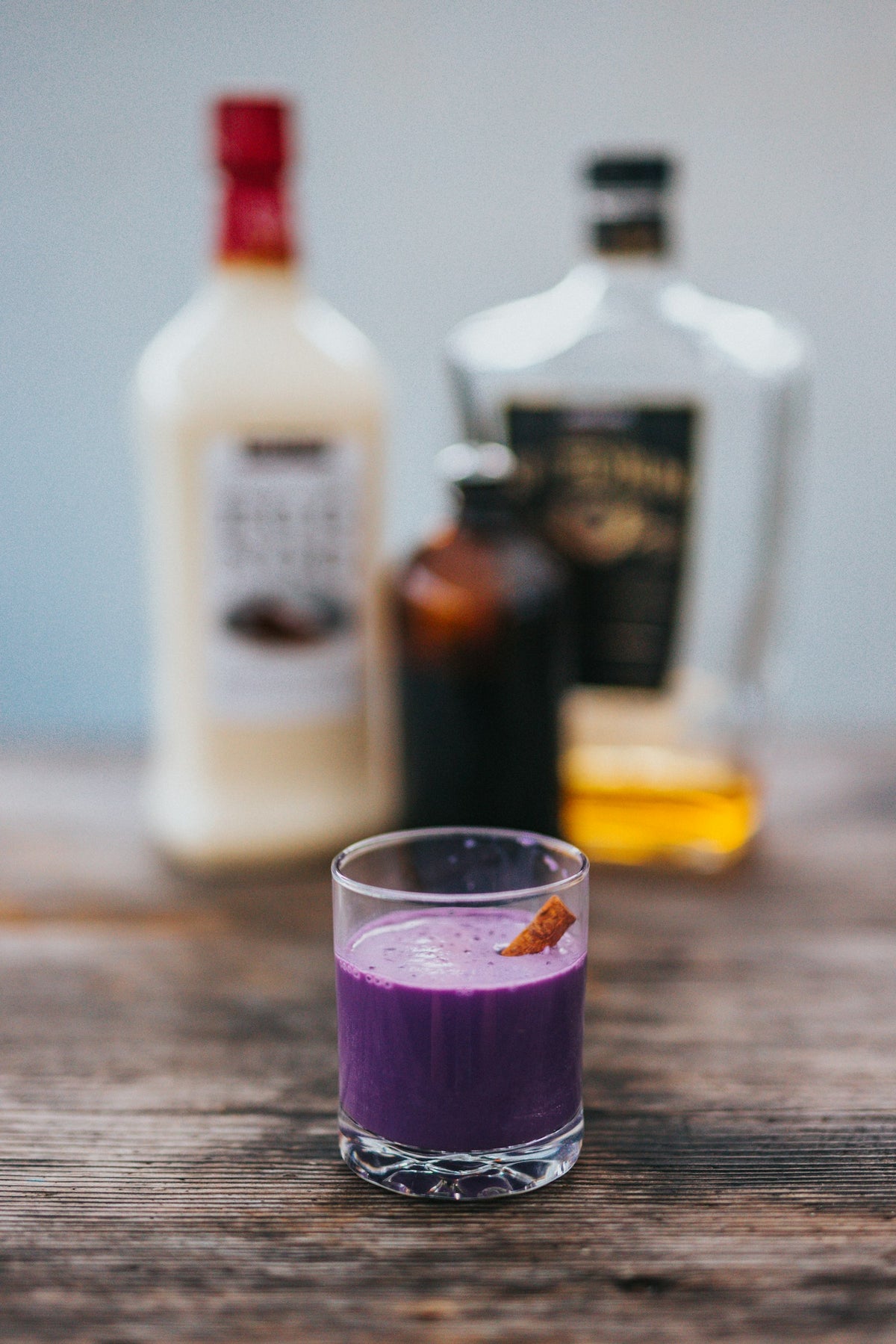 Homemade ube coffee creamer and ube syrup in jars beside iced coffee