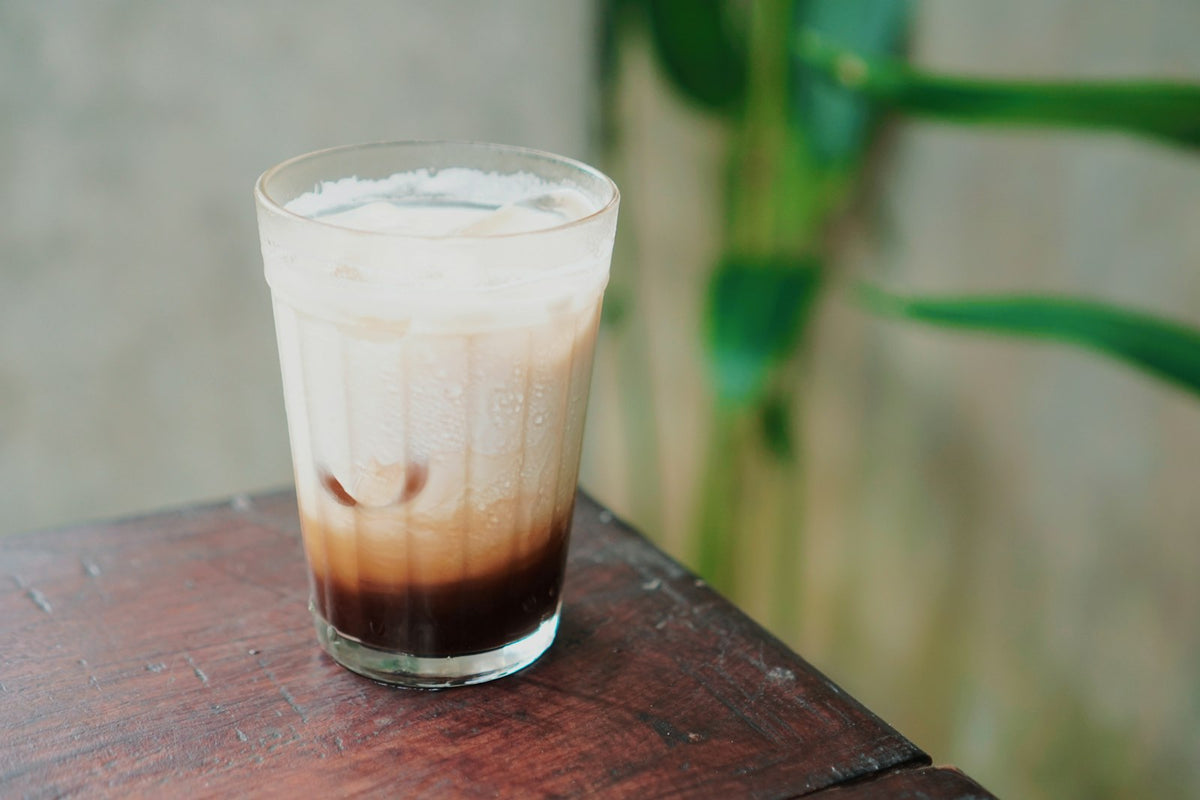 Iced Starbucks ube latte copycat with coconut milk and espresso in a tall glass